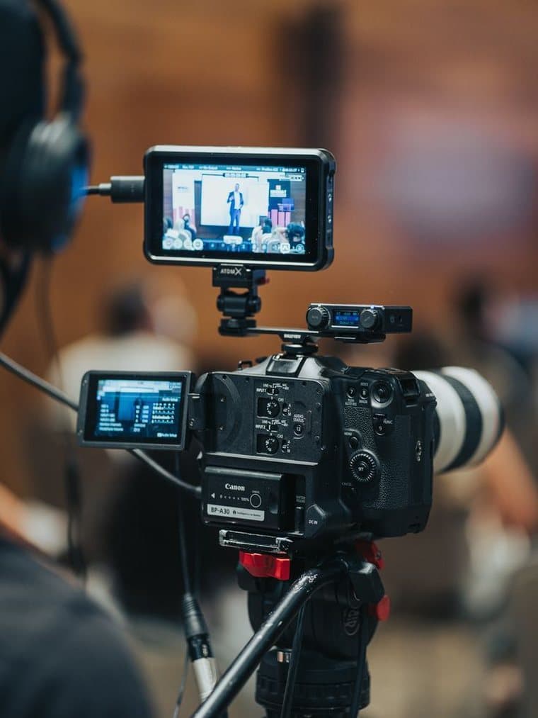A cinema camera rigged with a monitor, shooting a live event