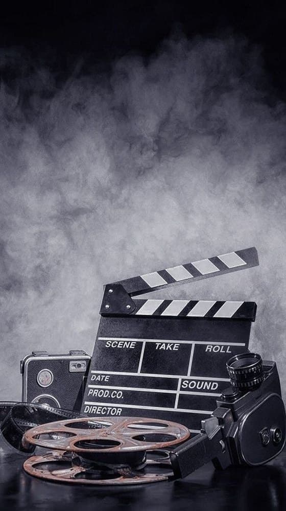 A clapperboard and film reels in low light